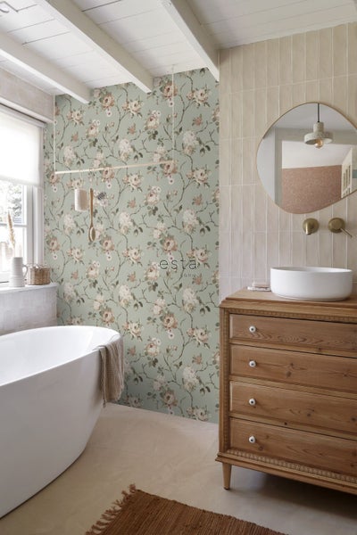 Badezimmer mit Badewanne, Kommode aus Holz, Spiegel und Tapete mit Blumenmuster