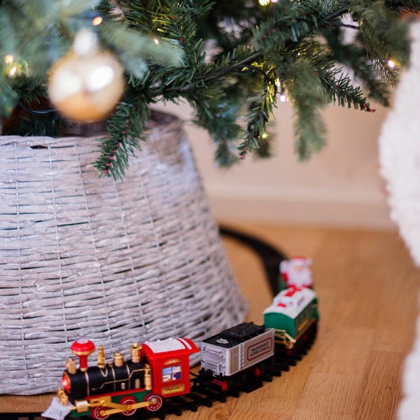 Weihnachtsbaum mit Baumschmuck, Korb und Spielzeugeisenbahn