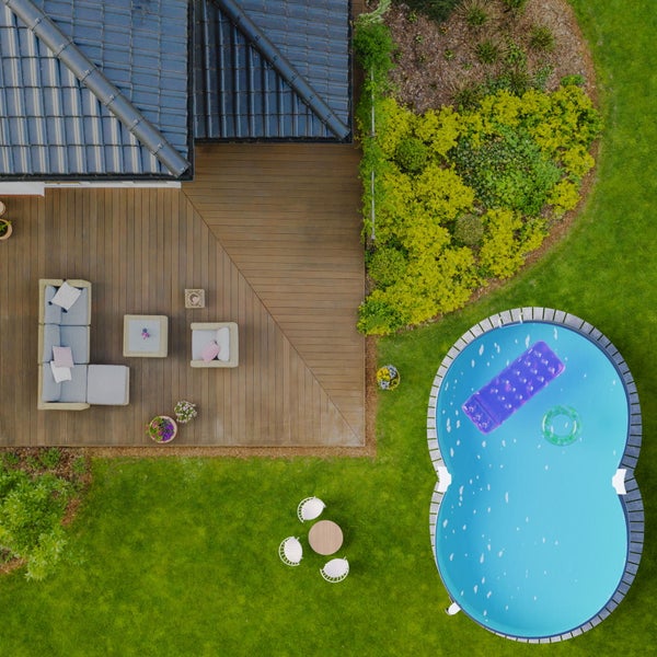 Draufsicht eines Gartens mit Haus, Terrasse, Gartenmöbeln und Pool