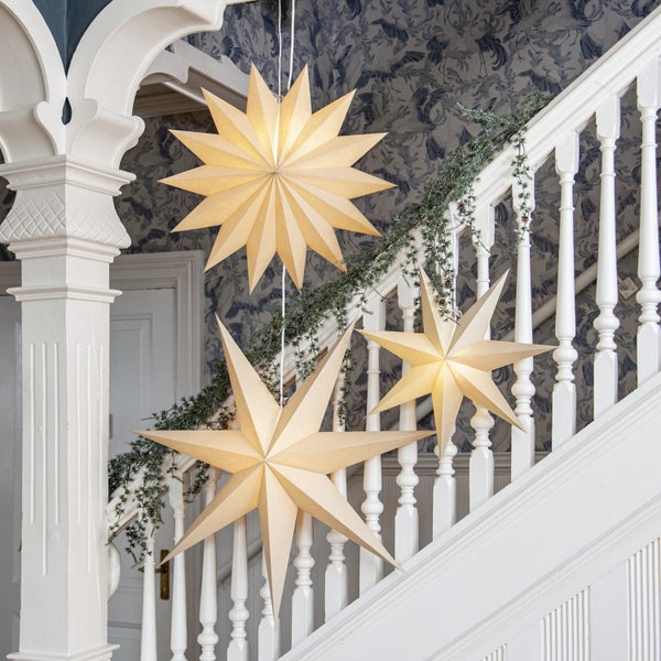 Treppenhausdekoration mit beleuchteten Papiersternen und Tannengirlande