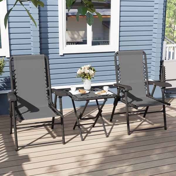 Zwei graue Garten-Relaxsessel und ein schwarzer Klapptisch auf einer Holzterrasse vor einer Hauswand.