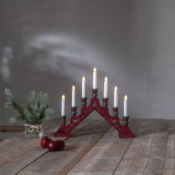Weihnachtsleuchter mit sieben Kerzen auf einem Holztisch