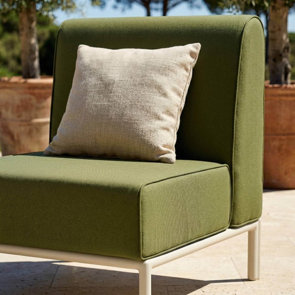 Moderner Lounge-Sessel für den Garten mit grünen Polstern, hellem Metallgestell und einem Dekokissen im Außenbereich.