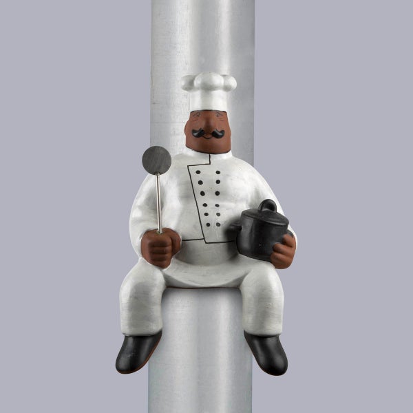 Dekorative Fallrohrfigur Koch mit weißer Kochmütze, weißer Jacke, schwarzem Topf und Pfannenwender.