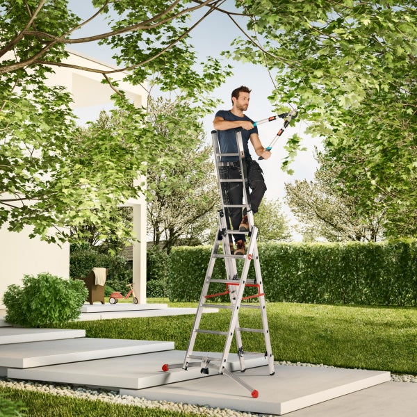 Mann auf einer Mehrzweckleiter, der mit einer Gartenschere einen Baum beschneidet.