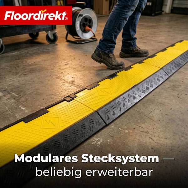 Modularer Kabelschutz auf Werkstattboden. Eine Person in Arbeitsschuhen steigt über das schwarz-gelbe System. Floordirekt Logo.