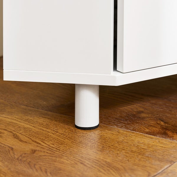 Detailansicht eines weißen Schranks mit rundem Fuß auf einem Holzboden