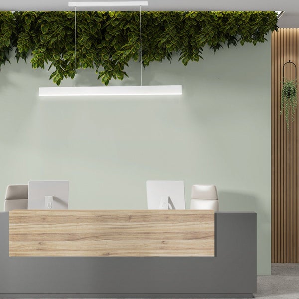 Moderner Empfangsbereich mit Tresen in Holzoptik, hängender LED Leuchte, grüner Wandgestaltung und Deckenbegrünung.