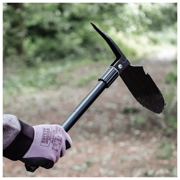 Person hält Multifunktionsspaten mit Hacke in der Hand