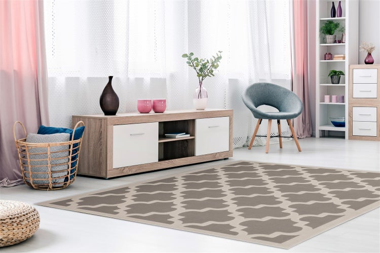 Wohnzimmer mit modernem Design, ausgestattet mit einem Teppich mit geometrischem Muster, einem TV-Board aus Holz, einem Sessel und einem Regal.