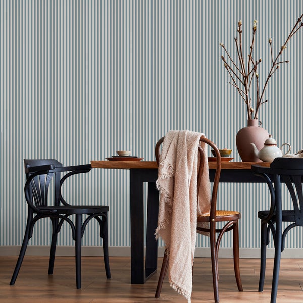 Gestreifte Tapete im Esszimmer mit Holztisch, schwarzen Stühlen, Holzstuhl mit Decke und Vase mit Zweigen auf Holzfußboden.