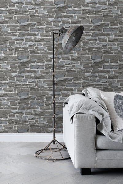 Wohnzimmer mit Steinmauer-Tapete, Stehlampe und Sofa