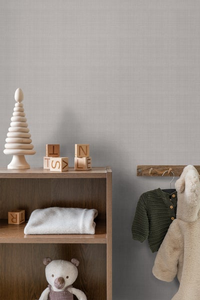 Helles Kinderzimmer mit Holzregal, Spielsachen und Kleidung an der Wand