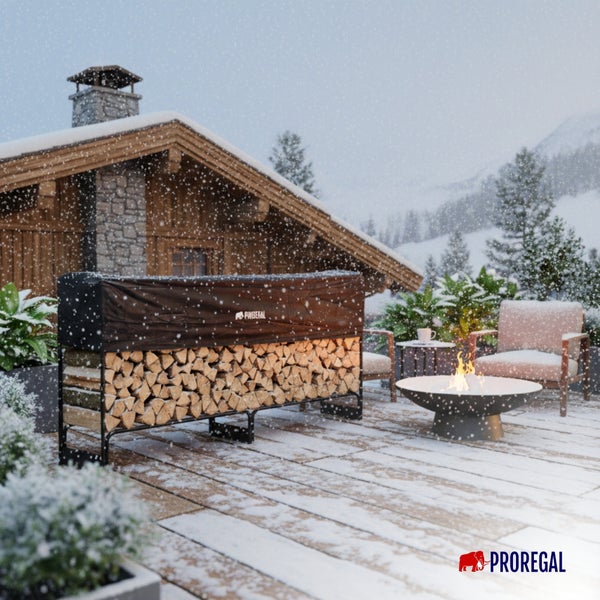 Kaminholzregal aus Metall mit Abdeckplane auf einer verschneiten Terrasse mit Feuerschale vor einem Holzhaus, PROREGAL Logo.