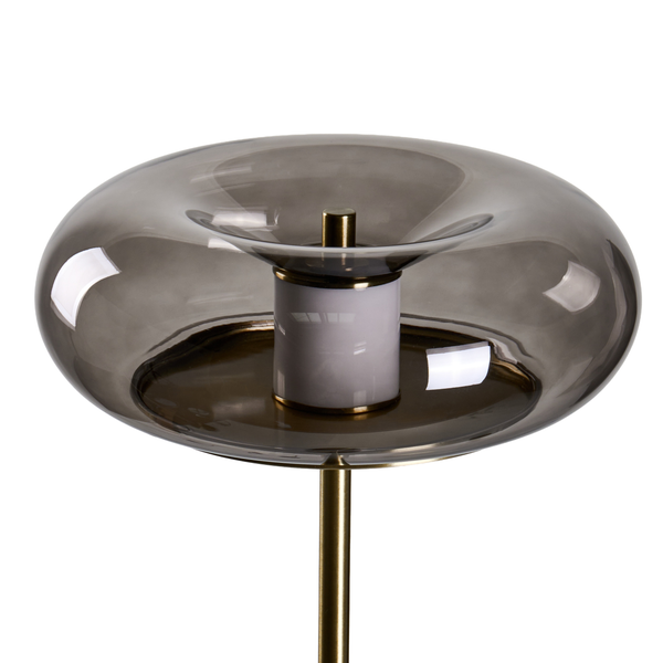 Moderne Stehleuchte mit rundem Glasschirm und Metallelementen auf einem Standfuß.