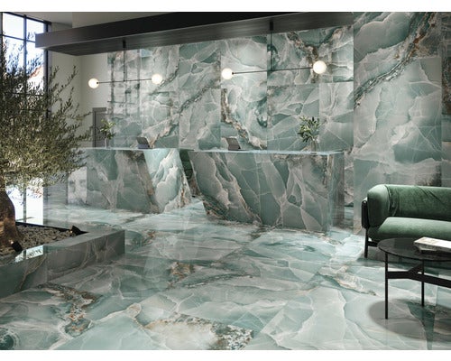 Heller, geräumiger Raum mit Bodenfliesen und Wandfliesen in Marmoroptik, Rezeption und Sitzecke.
