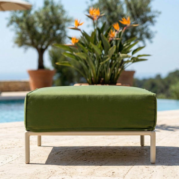 Grüner Gartenhocker mit hellem Metallgestell auf einer Terrasse am Pool.