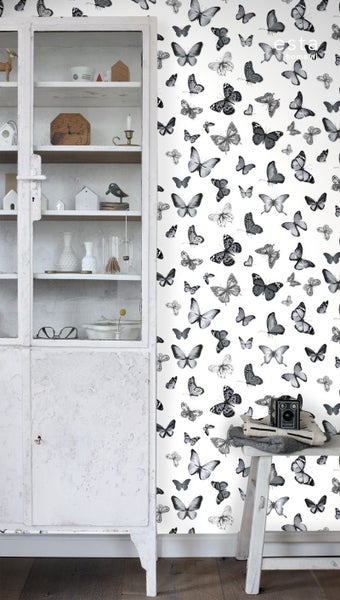 Szene mit einem weißen Schrank und einer Wandtapete mit Schmetterlingsmuster