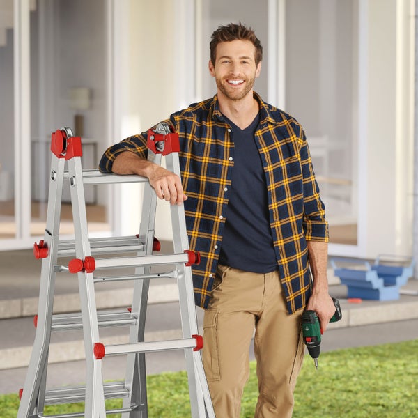 Mann mit Mehrzweckleiter und Akku-Bohrschrauber im Aussenbereich