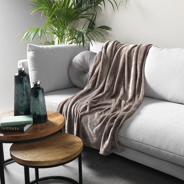 Wohnzimmerdekoration mit Sofa, Dekokissen, Tagesdecke, Beistelltischen und Dekovasen