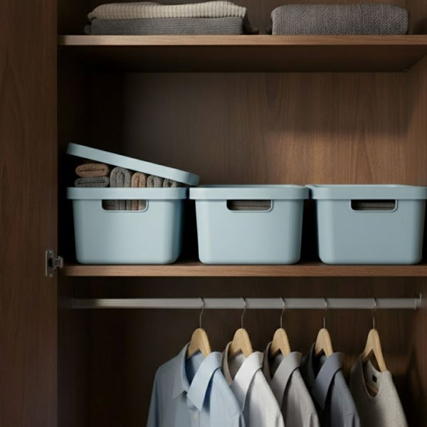 Kleiderschrank mit Aufbewahrungsboxen und Kleidung an Kleiderbügeln