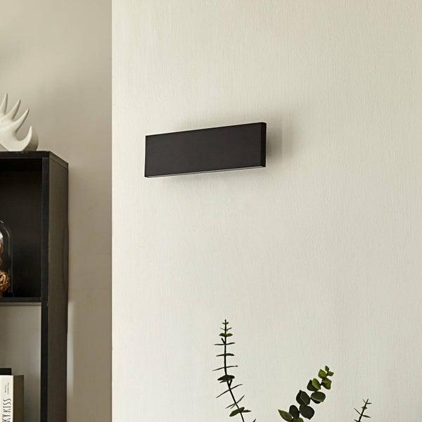 Moderne schwarze Wandleuchte in rechteckiger Form an einer hellen Wand montiert.