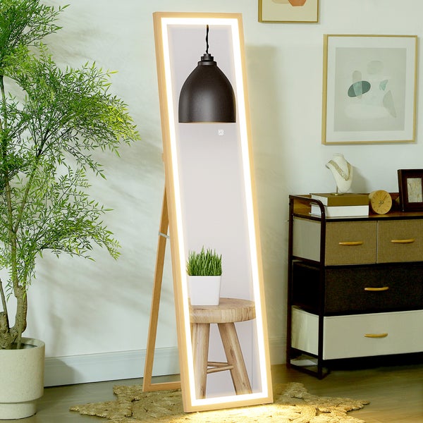 Ganzkörperspiegel mit integrierter LED Beleuchtung und Holzrahmen in einem hellen modernen Raum neben einer Zimmerpflanze und einer Kommode.