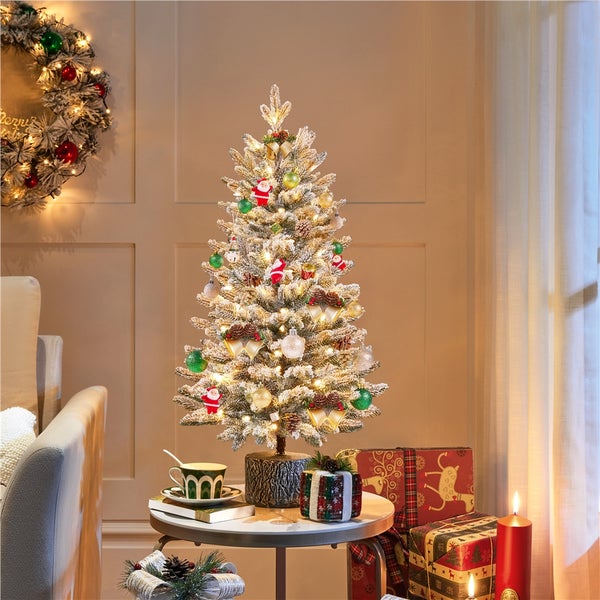 Dekorierter Weihnachtsbaum mit Weihnachtsschmuck, Geschenken und Kerzen auf einem Tisch