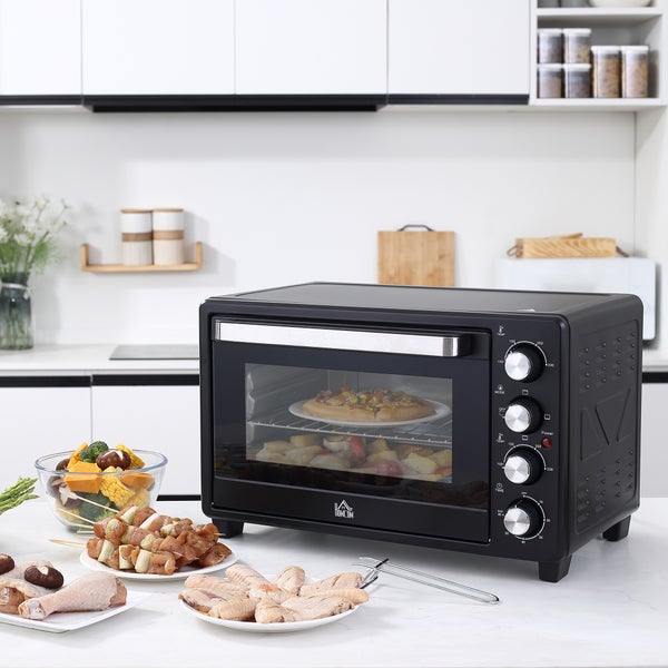 Mini-Backofen mit Homcom Logo in einer hellen Küche mit einer Pizza im Inneren sowie Fleisch und Gemüse auf der Arbeitsplatte.