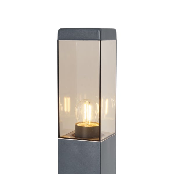 Moderne Außen-Sockelleuchte in Anthrazit mit Gehäuse aus Glas und eingeschaltetem Leuchtmittel.