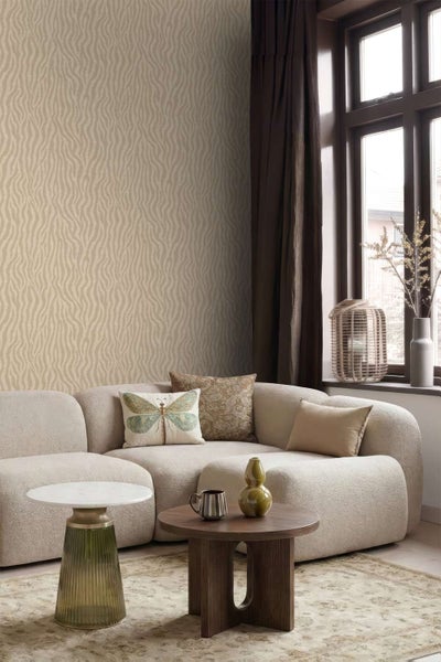 Wohnzimmer mit strukturierter Tapete mit Wellenmuster, einem modernen Sofa, Couchtischen und Dekoration in einem hellen, wohnlichen Ambiente.