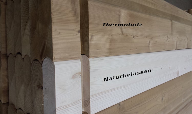 Vergleich von Thermoholz und naturbelassenem Holz an gestapelten Blockbohlen.