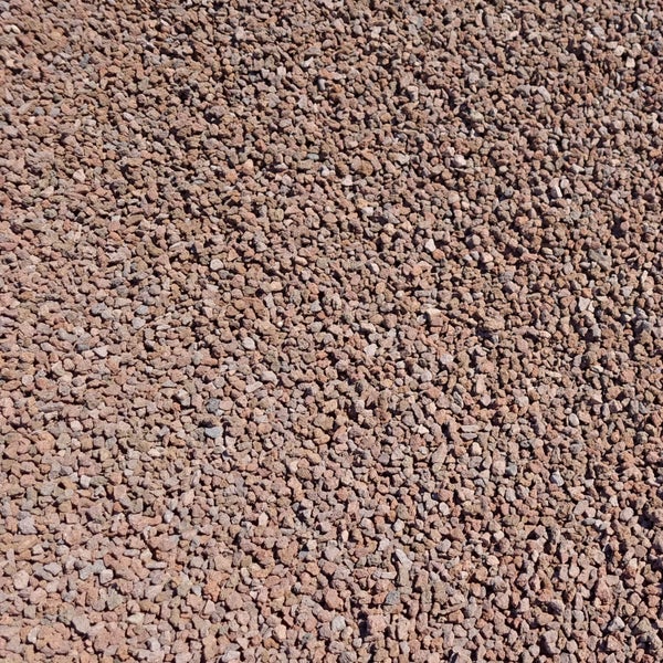 Nahaufnahme von feinem, rotbraunem Lavamulch aus porösem Lavagestein.