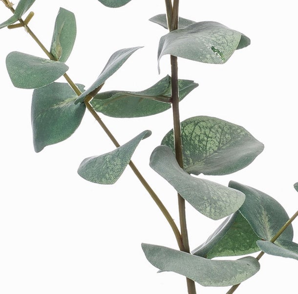 Künstliche Bambuspflanze mit mehreren braunen Halmen und grünen Blättern in einem schwarzen Topf.