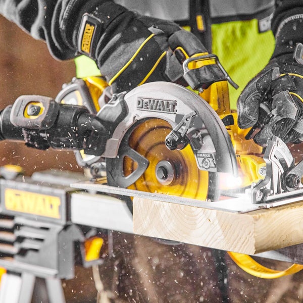 Person verwendet DeWalt Handkreissäge zum Zuschneiden eines Holzbalkens auf einem Sägebock.