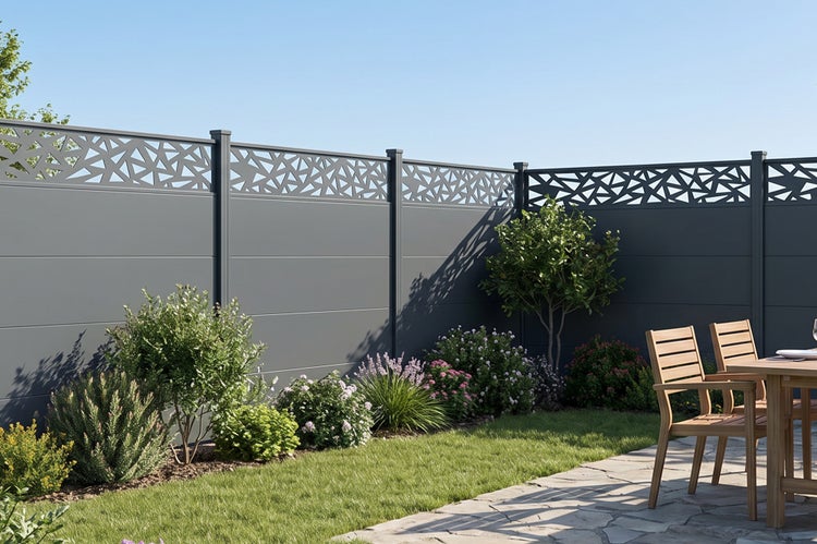 Moderne Sichtschutzwand aus Metall mit dekorativem Gittereinsatz im Garten vor einer Rasenfläche mit Stauden und Gartenmöbeln.
