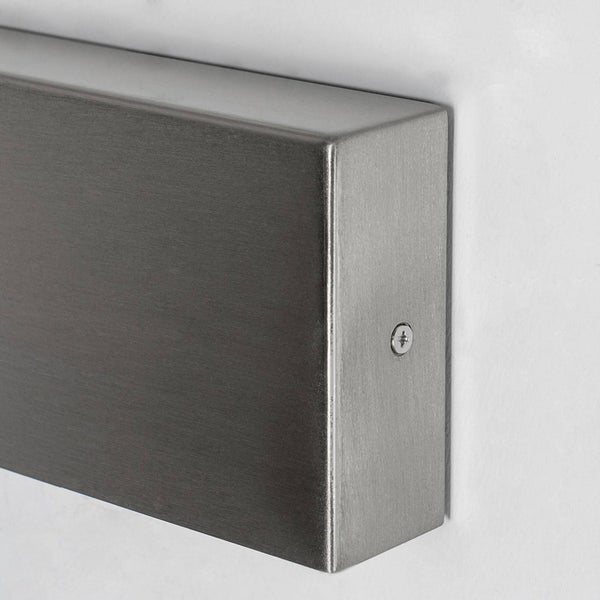 Nahaufnahme einer rechteckigen Wandhalterung aus gebürstetem Metall mit einer seitlichen Schraube.