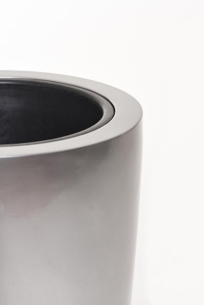 Detailaufnahme eines runden Pflanzgefäßes mit glatter metallischer Oberfläche und schwarzem Innenrand.