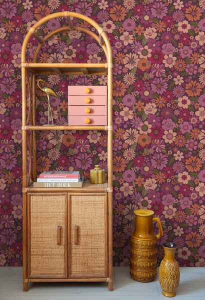 Einrichtung im Retro Stil mit einem Regal aus Rattan und einer floralen Tapete.