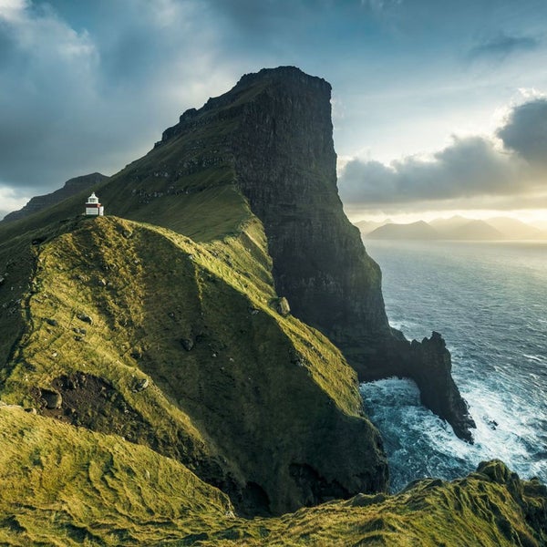 Landschaftsansicht mit einem Leuchtturm auf einer Klippe am Meer