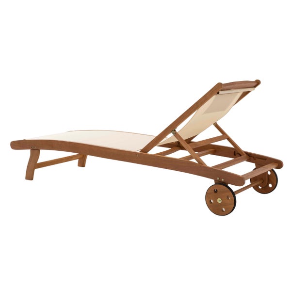 Sonnenliege aus braunem Holz mit beiger Textilbespannung, zwei Rollen und Kopfkissen.