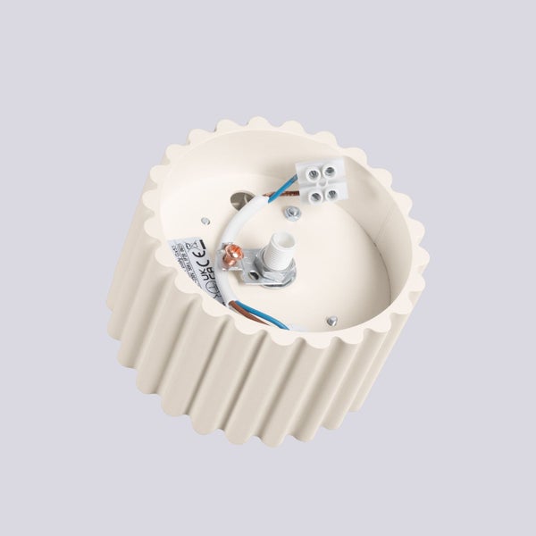 Innenansicht einer runden, geriffelten Leuchtenbasis mit elektrischer Verkabelung, Anschlussklemme und Anschlusspunkten.