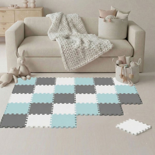 Ineinandergreifende Puzzlematte aus Schaumstoff im Schachbrett-Design in einem hellen Wohnzimmer mit Sofa, Strickdecke und Spielzeug.