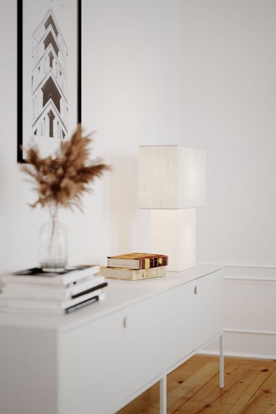 Helle Inneneinrichtung mit Kommode, Lampe, Büchern und Dekoration