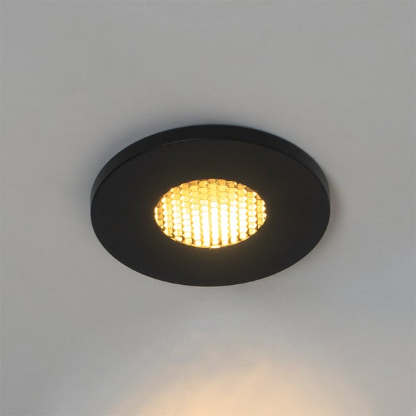 Runder schwarzer LED-Einbaustrahler mit Wabenmuster und warmweißem Licht.