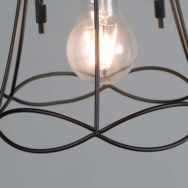 Detailaufnahme einer Pendelleuchte mit einem Leuchtmittel hinter einem schwarzen Drahtgestell