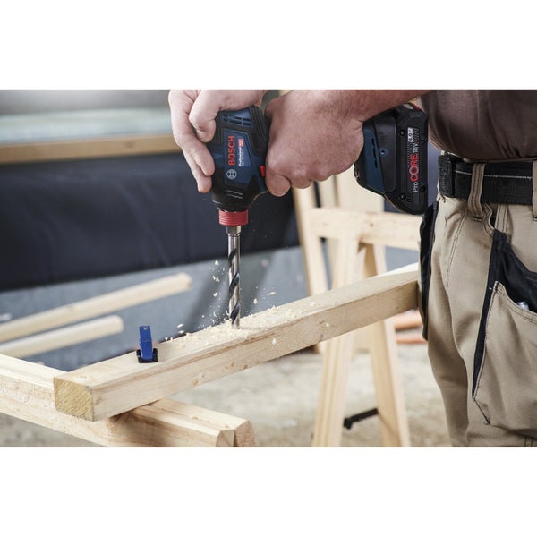 Ein Mann bohrt mit einem Akku-Schlagschrauber ein Loch in ein Holzbrett. Bosch Logo.