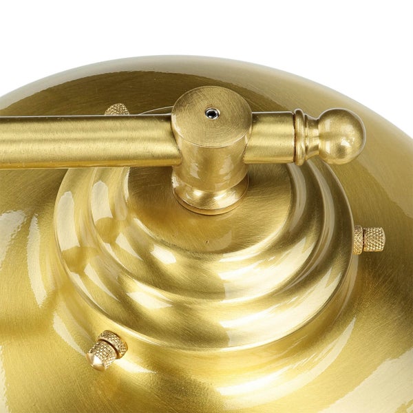 Detailaufnahme einer goldenen Lampe mit Verstellmechanismus.