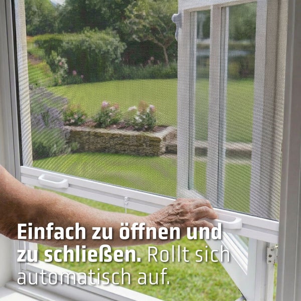 Weißes Insektenschutzrollo für Fenster mit Handgriff, feinmaschiges Fliegengitter wird per Hand geschlossen, Blick in den grünen Garten.