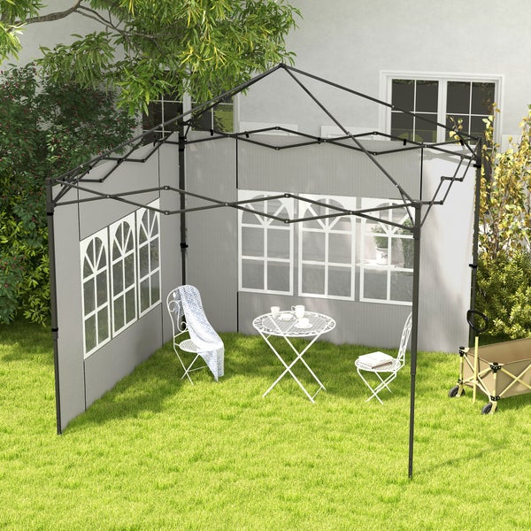 Ein grauer Faltpavillon mit Seitenwänden und Fenstermuster steht auf einer grünen Wiese neben einem Bollerwagen und weißen Gartenmöbeln aus Metall.